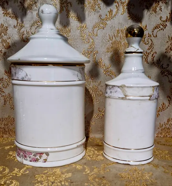 Foto de um(a) Raro e antigo par de potes de farmácia, da categoria de Garrafas, potes e jarros. Conjunto com 2 potes antigos de farmácia, sendo um de algodão e o outro de água de colônia. Ambos em porcelana com... Mostrado de uma perspectiva diferente. Vendido no marketplace Trésors.