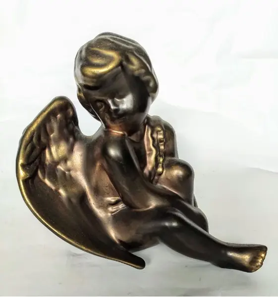 Foto de um(a) Anjo Dourado anos 80, da categoria de Modelos e estatuetas. Anjo em cerâmica revestido com pátina dourada oxidada, década de 1989. A: 16cm L: 13cm P: 18cm Peso: 440g. Mostrado de uma perspectiva diferente. Vendido no marketplace Trésors.