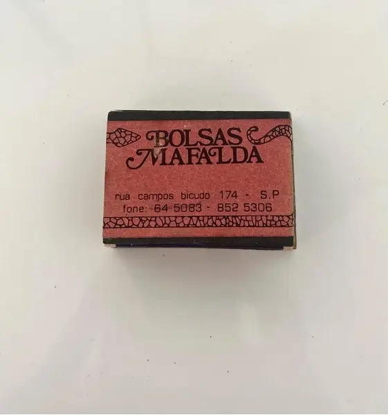 Foto de um(a) Caixa de fósforo e porcelana, da categoria de Outros colecionáveis. Caixa de fósforos com placa de porcelana com pintura de anjo. De uma extinta loja de bolsas de São Paulo, chamada “Mafalda”. Mostrado de uma perspectiva diferente. Vendido no marketplace Trésors.