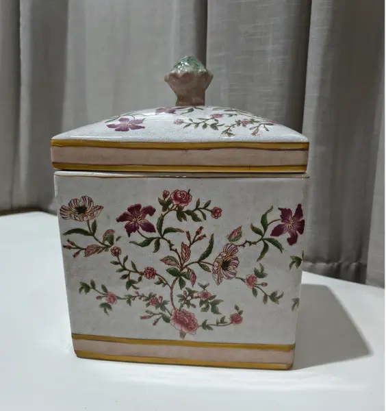 Foto de um(a) Antigo Pote Decorativo em Faiança com Tampa Floral, da categoria de Garrafas, potes e jarros. Produzido em porcelana/faiança de excelente espessura, a peça apresenta formato retangular e uma belíssima pintura botânica... Mostrado de uma perspectiva diferente. Vendido no marketplace Trésors.