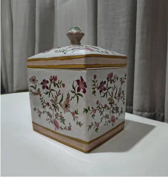 Foto de um(a) Antigo Pote Decorativo em Faiança com Tampa Floral, da categoria de Garrafas, potes e jarros. Produzido em porcelana/faiança de excelente espessura, a peça apresenta formato retangular e uma belíssima pintura botânica... Mostrado de uma perspectiva diferente. Vendido no marketplace Trésors.
