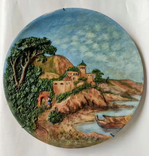Foto de um(a) Prato Alemão anos 70, da categoria de Pratos Decorativos. Prato de parede em terracota policromada e em relevo, década de 1970, procedência alemã. Diâmetro: 34cm Peso: 1.500kg. Mostrado de uma perspectiva diferente. Vendido no marketplace Trésors.