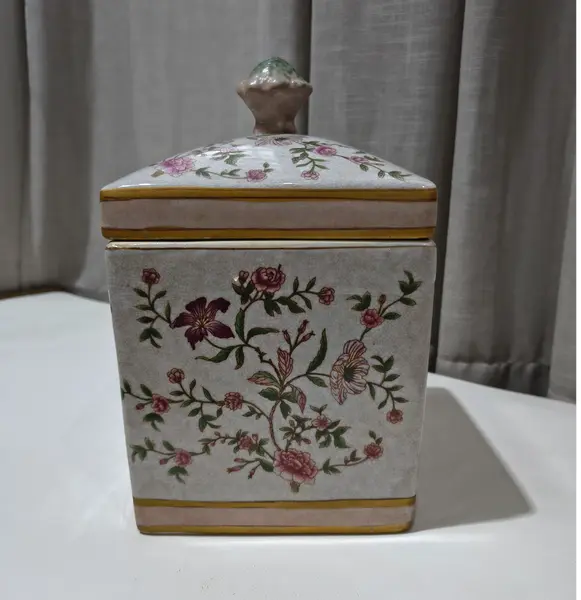 Foto de um(a) Antigo Pote Decorativo em Faiança com Tampa Floral, da categoria de Garrafas, potes e jarros. Produzido em porcelana/faiança de excelente espessura, a peça apresenta formato retangular e uma belíssima pintura botânica... Mostrado de uma perspectiva diferente. Vendido no marketplace Trésors.