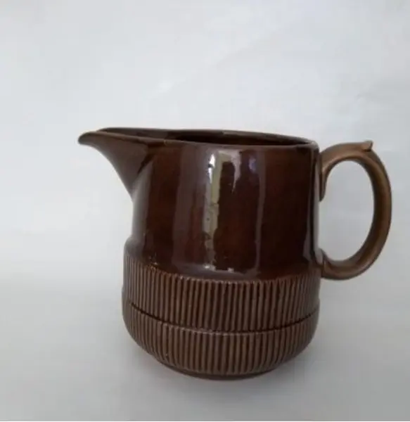 Foto de um(a) Jarra Esmaltada em Terracota, Déc. 1940, da categoria de Garrafas, potes e jarros. Jarra esmaltada em terracota marrom com relevo na parte de baixo, década de 1940. A: 16cm / D: 15cm Peso: 910g. Mostrado de uma perspectiva diferente. Vendido no marketplace Trésors.