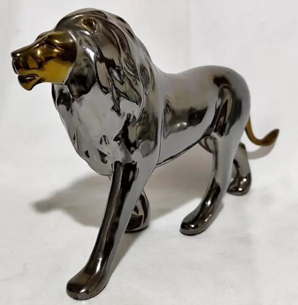 Foto de um(a) Grande escultura decorativo de leão, da categoria de Escultura. Grande escultura decorativo de leão em material rígido em tons dourado e fumê. Medidas 20,5 cm alt. X 33 cm compr. Mostrado de uma perspectiva diferente. Vendido no marketplace Trésors.