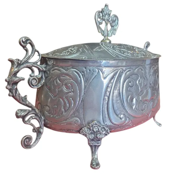 Foto de um(a) Antiga Terrina Decorativa em Metal Prateado, da categoria de Cachepot. Elegante recipiente oval com tampa, ricamente adornado com motivos florais e volutas em relevo. Uma peça de destaque para... Vendido no marketplace Trésors.