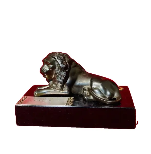 Foto de um(a) Troféu Leão do Ano, 71/72, da categoria de Escultura. Troféu Lions 1971/1972 - Leão do Ano. Em bronze com base de granito preto. A: 7 cm / L: 12 cm / P: 7,4 cm peso: 738 g. Vendido no marketplace Trésors.
