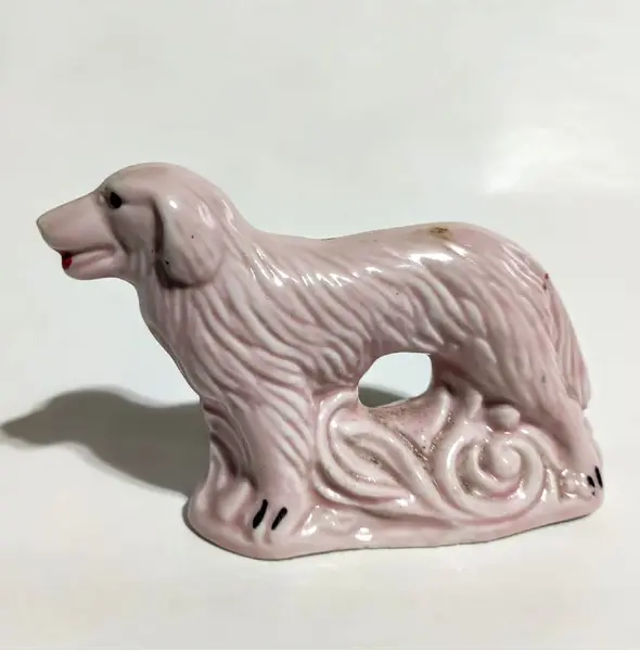 Foto de um(a) Bibelô Collie Anos 40, da categoria de Modelos e estatuetas. Miniatura em porcelana na cor rosa, o clássico bibelô dos anos 1940 A: 8 cm P: 4 cm L: 11 cmPeso: 158 g. Mostrado de uma perspectiva diferente. Vendido no marketplace Trésors.