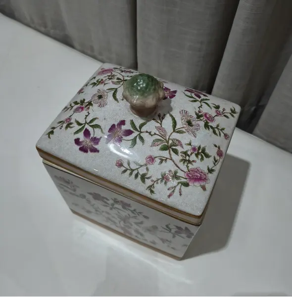 Foto de um(a) Antigo Pote Decorativo em Faiança com Tampa Floral, da categoria de Garrafas, potes e jarros. Produzido em porcelana/faiança de excelente espessura, a peça apresenta formato retangular e uma belíssima pintura botânica... Mostrado de uma perspectiva diferente. Vendido no marketplace Trésors.