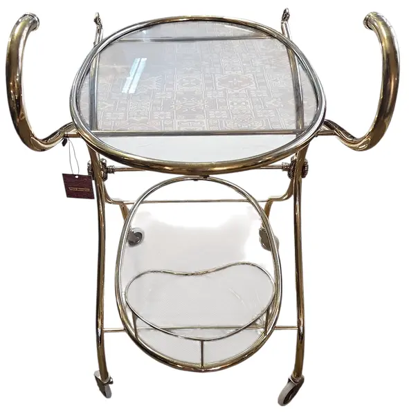 Foto de um(a) Carrinho de Chá Italiano – Bronze e Latão com Vidro Temperado, da categoria de Carrinhos de bar e auxiliares. Exemplar sofisticado do design europeu, este carrinho de chá (ou carrinho bar) combina a robustez do bronze com o brilho... Mostrado de uma perspectiva diferente. Vendido no marketplace Trésors.