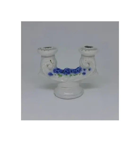 Foto de um(a) Candelabro de porcelana para duas velas, da categoria de Castiçais. Candelabro de porcelana para duas velas, com detalhes de flores em tom de azul, folhas verdes e fio dourado. Mede A: 12cm L:... Mostrado de uma perspectiva diferente. Vendido no marketplace Trésors.