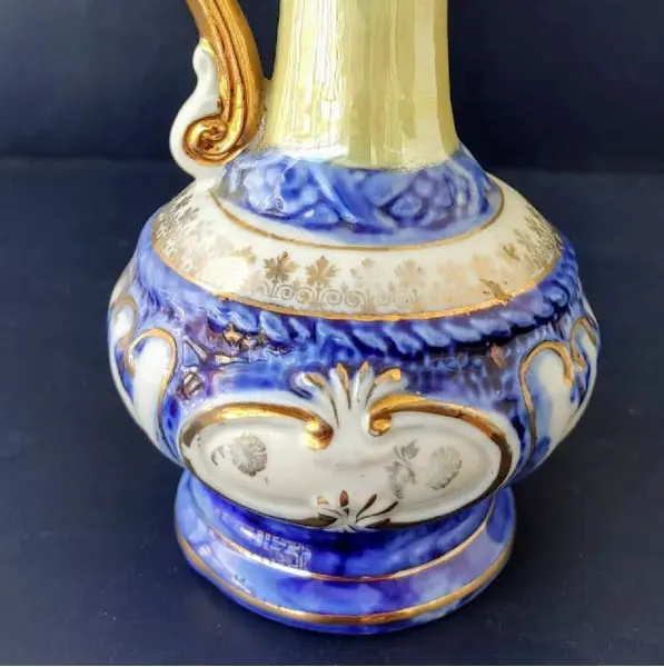 Foto de um(a) Pequena Jarra Blue anos 40, Indústria Brasileira, da categoria de Jarros. Pequena jarra em porcelana com pintura azul cobalto e amarelo perolado, filetada com ouro e grega com trevos também ouro... Mostrado de uma perspectiva diferente. Vendido no marketplace Trésors.