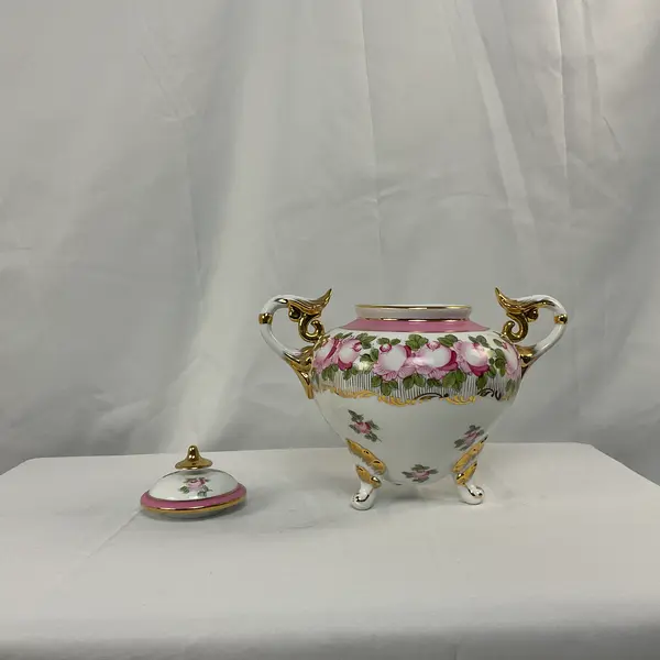 Foto de um(a) Vaso em Porcelana Branco com Pinturas de Rosas, da categoria de Vasos. Vaso em porcelana de coloração branca, com detalhes em rosa e dourado. Pintura representando flores. Mostrado de uma perspectiva diferente. Vendido no marketplace Trésors.