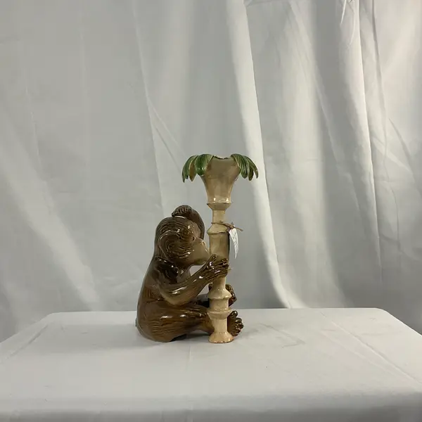 Foto de um(a) Castiçal em Cerâmica em Forma de Macaco, da categoria de Castiçais. Castiçal fabricado em cerâmica, representando um macaco junto a um pilar com folhas. Mostrado de uma perspectiva diferente. Vendido no marketplace Trésors.