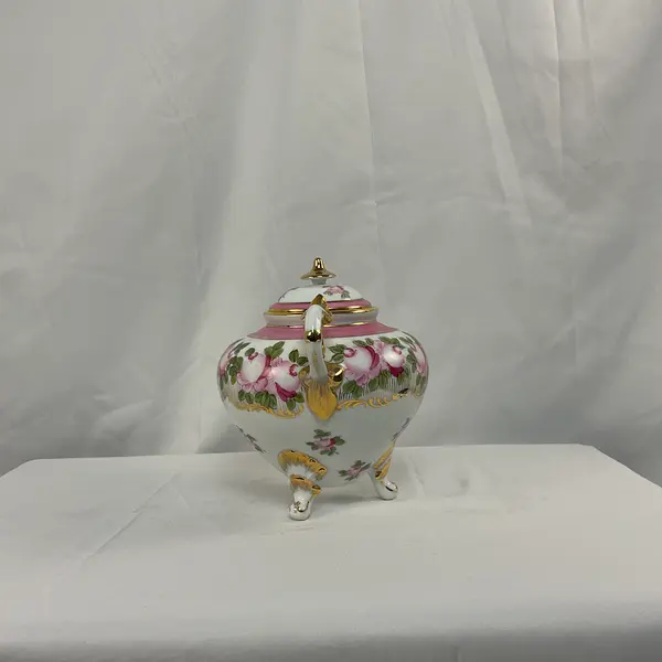 Foto de um(a) Vaso em Porcelana Branco com Pinturas de Rosas, da categoria de Vasos. Vaso em porcelana de coloração branca, com detalhes em rosa e dourado. Pintura representando flores. Mostrado de uma perspectiva diferente. Vendido no marketplace Trésors.