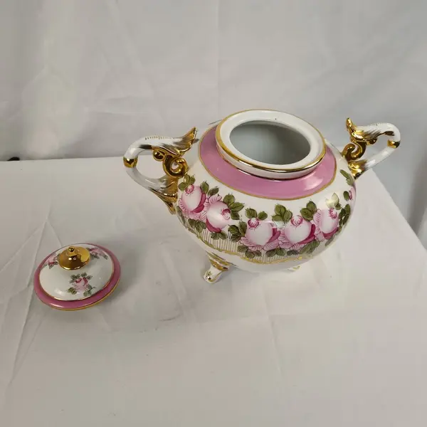 Foto de um(a) Vaso em Porcelana Branco com Pinturas de Rosas, da categoria de Vasos. Vaso em porcelana de coloração branca, com detalhes em rosa e dourado. Pintura representando flores. Mostrado de uma perspectiva diferente. Vendido no marketplace Trésors.
