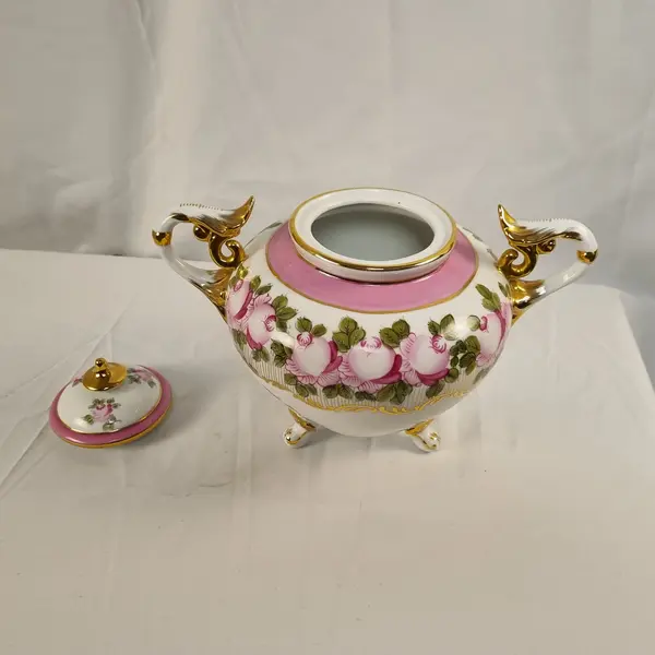 Foto de um(a) Vaso em Porcelana Branco com Pinturas de Rosas, da categoria de Vasos. Vaso em porcelana de coloração branca, com detalhes em rosa e dourado. Pintura representando flores. Mostrado de uma perspectiva diferente. Vendido no marketplace Trésors.