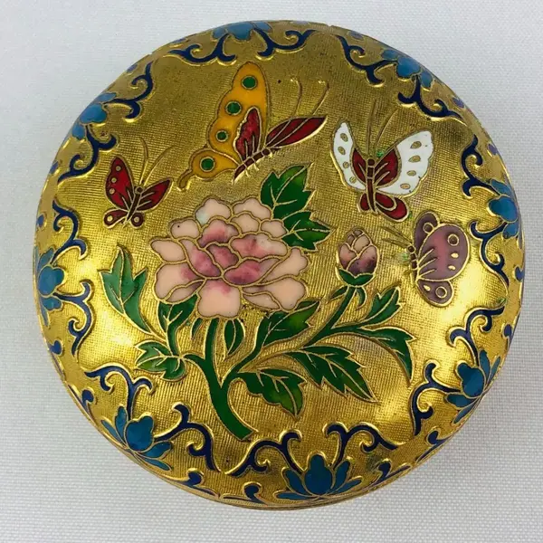 Foto de um(a) Porta-jóia em metal dourado, da categoria de Porta-Jóias. Porta-jóia em metal dourado com figura de borboletas e flor em policromia, interior na cor azul. Mede 4cm altura x 7cm... Mostrado de uma perspectiva diferente. Vendido no marketplace Trésors.