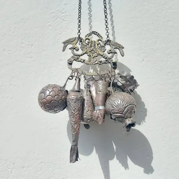Foto de um(a) Penca de balangandã baiana em metal, da categoria de Objetos religiosos e espirituais. Antiga penca de balangandã baiana em metal com nove balangandãs diversos. O balangandã é um objeto de significado ritual... Mostrado de uma perspectiva diferente. Vendido no marketplace Trésors.