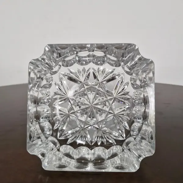 Foto de um(a) Cinzeiro em cristal, da categoria de Cinzeiros. Antigo cinzeiro em cristal translúcido ricamente lapidado. Valor individual! Medidas: 14 cm x 14 cm. Mostrado de uma perspectiva diferente. Vendido no marketplace Trésors.