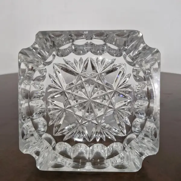 Foto de um(a) Cinzeiro em cristal, da categoria de Cinzeiros. Antigo cinzeiro em cristal translúcido ricamente lapidado. Valor individual! Medidas: 14 cm x 14 cm. Mostrado de uma perspectiva diferente. Vendido no marketplace Trésors.