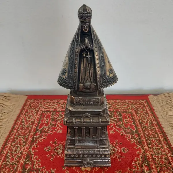Foto de um(a) Imagem Nossa Senhora Aparecida em metal, da categoria de Objetos religiosos e espirituais. Antiga e linda imagem de Nossa Senhora Aparecida em metal. Medidas: altura 23 cm x largura 8,5 cm. Mostrado de uma perspectiva diferente. Vendido no marketplace Trésors.