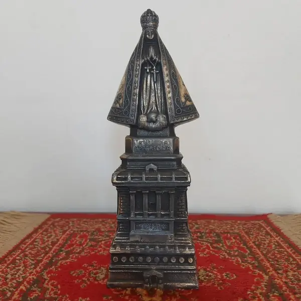Foto de um(a) Imagem Nossa Senhora Aparecida em metal, da categoria de Objetos religiosos e espirituais. Antiga e linda imagem de Nossa Senhora Aparecida em metal. Medidas: altura 23 cm x largura 8,5 cm. Mostrado de uma perspectiva diferente. Vendido no marketplace Trésors.