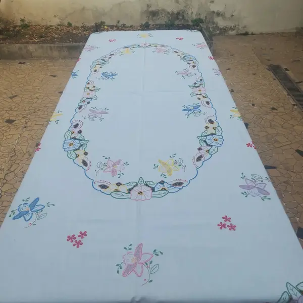 Foto de um(a) Toalha de mesa bordada, da categoria de Toalhas de Mesa. Belissima e grandiosa toalha de mesa bordada com flores coloridas. Medidas: comprimento 285 cm x largura 150 cm. Mostrado de uma perspectiva diferente. Vendido no marketplace Trésors.