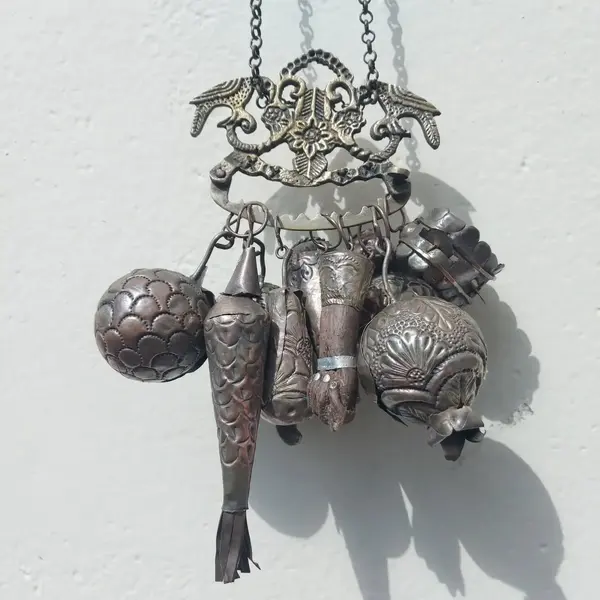 Foto de um(a) Penca de balangandã baiana em metal, da categoria de Objetos religiosos e espirituais. Antiga penca de balangandã baiana em metal com nove balangandãs diversos. O balangandã é um objeto de significado ritual... Mostrado de uma perspectiva diferente. Vendido no marketplace Trésors.