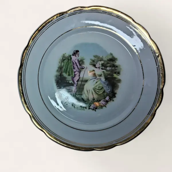 Foto de um(a) Prato decorativo em porcelana Real, da categoria de Pratos Decorativos. Prato com bordas douradas e centro com cena galante. Lindo e em ótimo estado. Porcelana Real. Acompanha suporte regulável em... Mostrado de uma perspectiva diferente. Vendido no marketplace Trésors.