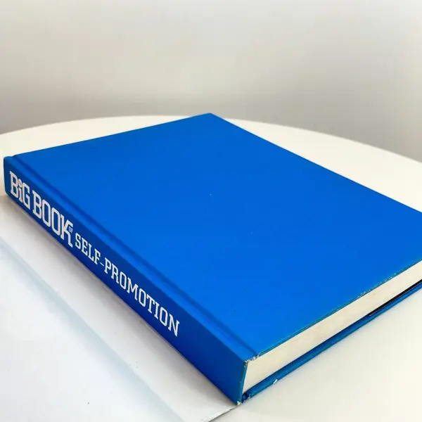 Foto de um(a) Livro capa dura - Big Book Self Promotion, da categoria de Livros. Livro capa dura com sobrecapa, primeira edição de 2009. Marcas do tempo. Mostrado de uma perspectiva diferente. Vendido no marketplace Trésors.