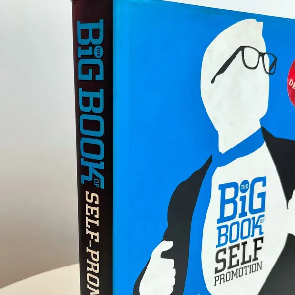Foto de um(a) Livro capa dura - Big Book Self Promotion, da categoria de Livros. Livro capa dura com sobrecapa, primeira edição de 2009. Marcas do tempo. Mostrado de uma perspectiva diferente. Vendido no marketplace Trésors.