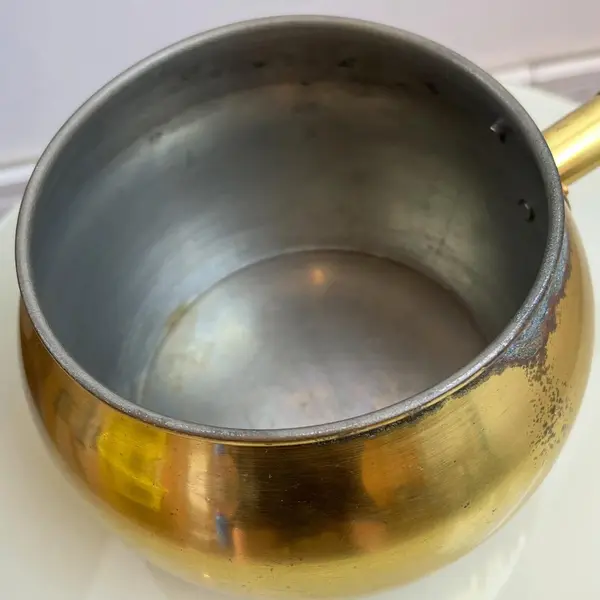 Foto de um(a) ​Panela decorativa em metal, da categoria de Panelas. Panela decorativa em metal amarelo e cabo em madeira. Apresenta charmosas marcas do tempo. Medidas: 32x11x16cm. Mostrado de uma perspectiva diferente. Vendido no marketplace Trésors.