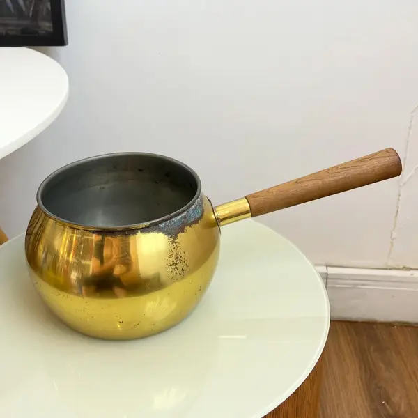 Foto de um(a) ​Panela decorativa em metal, da categoria de Panelas. Panela decorativa em metal amarelo e cabo em madeira. Apresenta charmosas marcas do tempo. Medidas: 32x11x16cm. Mostrado de uma perspectiva diferente. Vendido no marketplace Trésors.