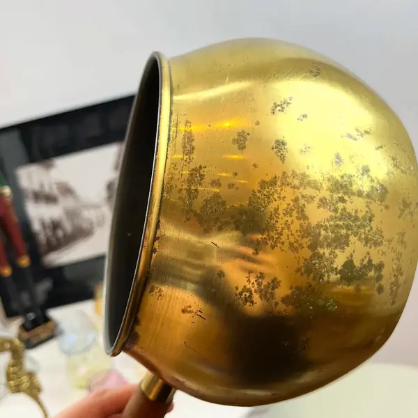 Foto de um(a) ​Panela decorativa em metal, da categoria de Panelas. Panela decorativa em metal amarelo e cabo em madeira. Apresenta charmosas marcas do tempo. Medidas: 32x11x16cm. Mostrado de uma perspectiva diferente. Vendido no marketplace Trésors.