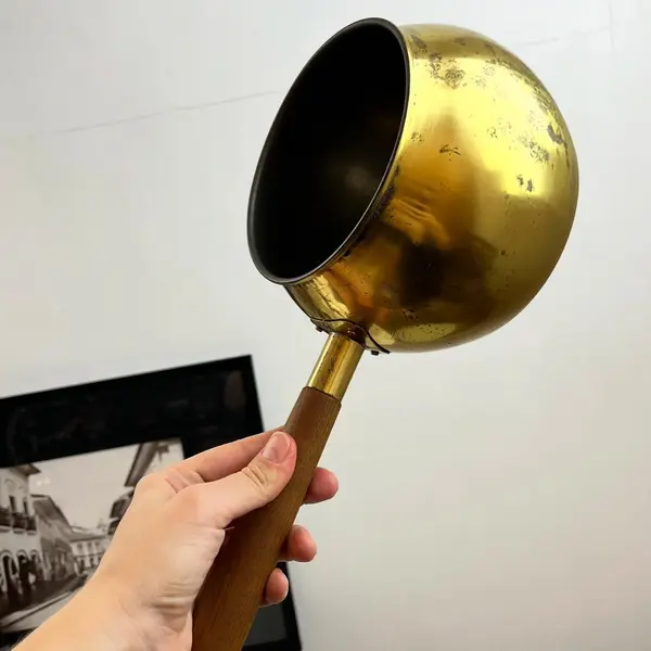 Foto de um(a) ​Panela decorativa em metal, da categoria de Panelas. Panela decorativa em metal amarelo e cabo em madeira. Apresenta charmosas marcas do tempo. Medidas: 32x11x16cm. Mostrado de uma perspectiva diferente. Vendido no marketplace Trésors.