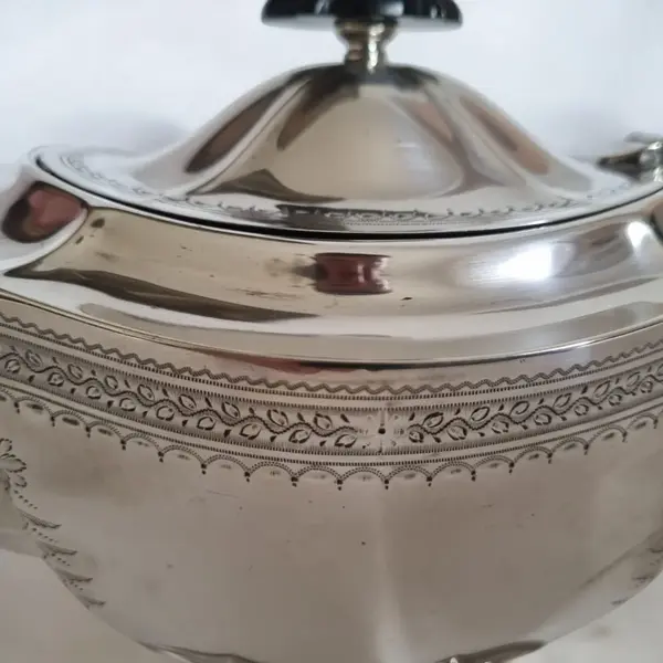 Foto de um(a) Bule de chá antigo Inglês, da categoria de Bules. E.P.N.S Unity at Plate E.P.N.S. é a abreviação de "Electro-Plated Nickel Silver", traduzido como "prata de níquel... Mostrado de uma perspectiva diferente. Vendido no marketplace Trésors.