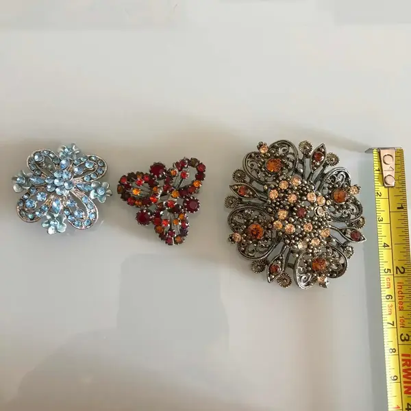 Foto de um(a) Lote Com 3 Finos Broches Com Pedras Coloridas, da categoria de Outros colecionáveis. Lote com 3 broches vintage, em ótimo estado de conservação. Mostrado de uma perspectiva diferente. Vendido no marketplace Trésors.