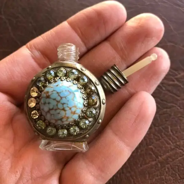 Foto de um(a) Antigo Pequeno Perfumeiro De Coleção Com Pedras, da categoria de Perfumeiros. Pequeno perfumeiro feito a mão. Usado antigamente para levar no bolso para viagens. Item de colecionador. Mede aprox 5cm. Mostrado de uma perspectiva diferente. Vendido no marketplace Trésors.