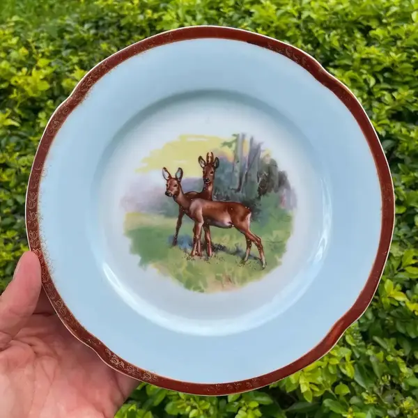 Foto de um(a) Antigo Prato Decorativo Porcelana Alemã Com Alces, da categoria de Pratos Decorativos. Antigo prato decorativo em porcelana artística alemã, decoração com alces e filetes de ouro. Diâmetro 21cm. Mostrado de uma perspectiva diferente. Vendido no marketplace Trésors.