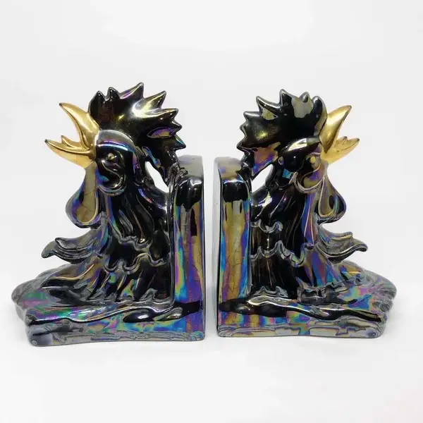 Foto de um(a) Antigo Cerra Livros Escultura De Galo Porcelana Art Deco, da categoria de Apoio para livros. Antigo e grande cerra livros em porcelana artística com figuras de galos, ricamente pintados à mão, e filetes em ouro.... Mostrado de uma perspectiva diferente. Vendido no marketplace Trésors.