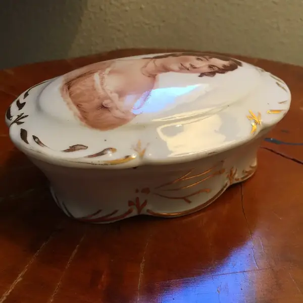 Foto de um(a) Antiga Caixa Porta Jóias Porcelana Alemã Pintado À Mão, da categoria de Porta-Jóias. Antiga caixa em porcelana antiga, com figura de dama pintada à mão. Alt: 7cmComp: 15cmLarg: 11cm. Mostrado de uma perspectiva diferente. Vendido no marketplace Trésors.