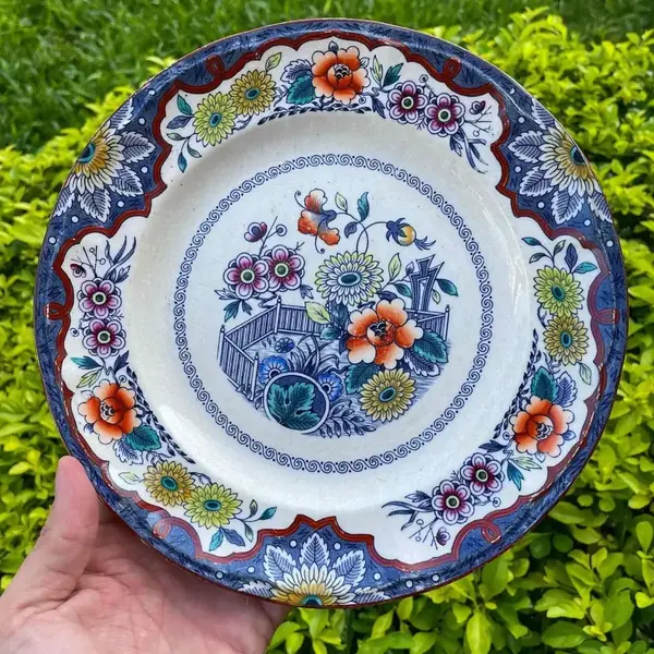 Foto de um(a) Antigo Raro Prato Decorativo Em Porcelana Holandesa Floral, da categoria de Pratos Decorativos. Antigo prato decorativo em porcelana artística holandesa. Lindas cores e decoração floral. Diâmetro 24cm. Mostrado de uma perspectiva diferente. Vendido no marketplace Trésors.