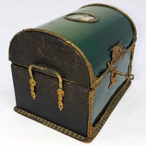 Foto de um(a) Antiga Caixa Porta Jóias Baú Bronze Ormolu Estilo Império, da categoria de Cestos e Caixas. Germany. Antiga e fina caixa porta jóias no formato de baú, com partes em couro e acabamento em bronze ormolu (com banho de... Mostrado de uma perspectiva diferente. Vendido no marketplace Trésors.