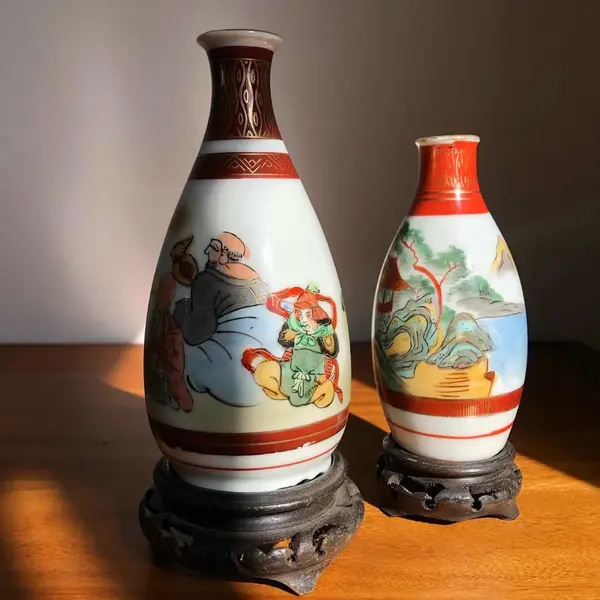 Foto de um(a) Antigo Par De Pequenos Vasos Orientais Porcelana Japonesa, da categoria de Vasos. Antigo par de vasinhos orientais em porcelana japonesa, pintados à mão. Base em madeira de lei. Altura 14 e 17cm. Mostrado de uma perspectiva diferente. Vendido no marketplace Trésors.
