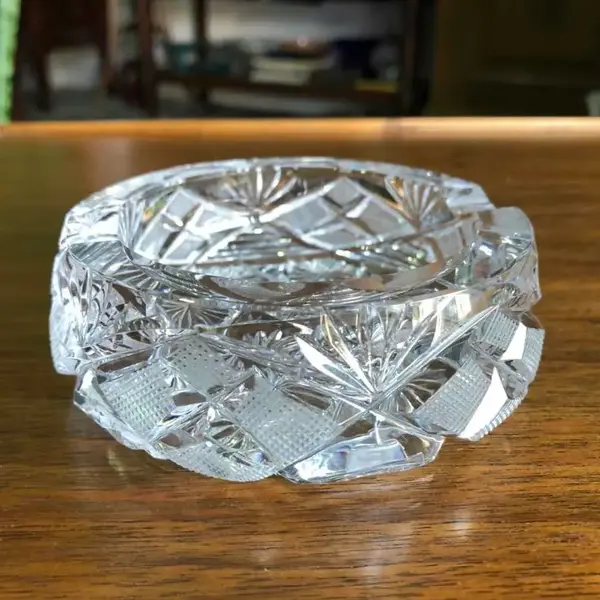 Foto de um(a) Antigo Lindo Cinzeiro Em Fino Cristal Tcheco Lapidado À Mão, da categoria de Cinzeiros. Ricamente lapidado à mão, com o fundo estrelado. Impecável. Meados do século XX. Altura 4cmDiâmetro 9cm. Mostrado de uma perspectiva diferente. Vendido no marketplace Trésors.
