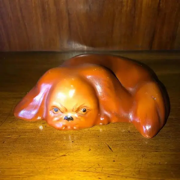 Foto de um(a) Antiga Linda Escultura Bibelô Cachorro Em Porcelana Alemã, da categoria de Modelos e estatuetas. Antigo bibelô de cachorro deitadinho em porcelana alemã. Década de 1950. Medidas 9x13cm. Mostrado de uma perspectiva diferente. Vendido no marketplace Trésors.