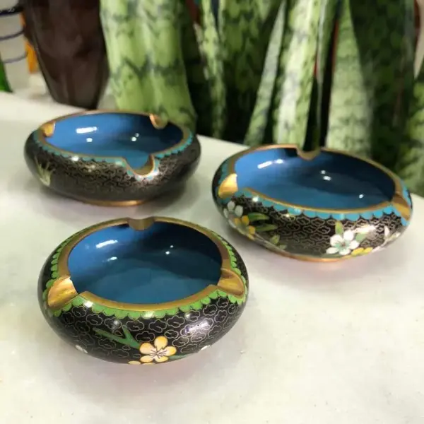 Foto de um(a) Antigo Trio De Cinzeiros Orientais Em Bronze Cloisonné, da categoria de Cinzeiros. Antigos e lindos cinzeiros orientais feitos à mão em Cloisonné. Decorados com flores e folhagens, com esmalte azul na parte... Mostrado de uma perspectiva diferente. Vendido no marketplace Trésors.