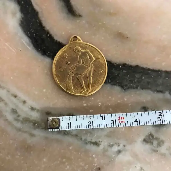 Foto de um(a) Antiga Rara Medalha Pingente Dourado Do Signo Aquário, da categoria de Outros colecionáveis. Rara medalha italiana, atrás têm o mês que começa e termina em italiano. Meados do século XX. Banhada a ouro 18kaprox 2.5cm. Mostrado de uma perspectiva diferente. Vendido no marketplace Trésors.
