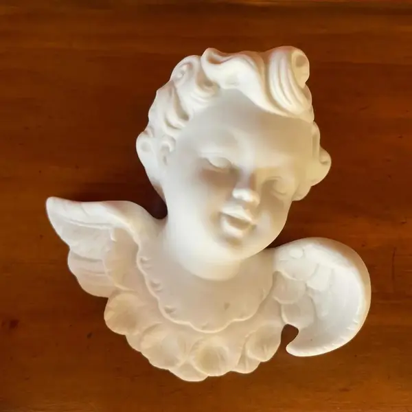 Foto de um(a) Antiga Escultura De Parede Anjo Em Biscuit Francês Branco, da categoria de Objetos de parede esculturais. Antiga escultura anjinho de parede em biscuit francês, peça artística feita e moldada à mão. Medidas 12x13cm. Mostrado de uma perspectiva diferente. Vendido no marketplace Trésors.